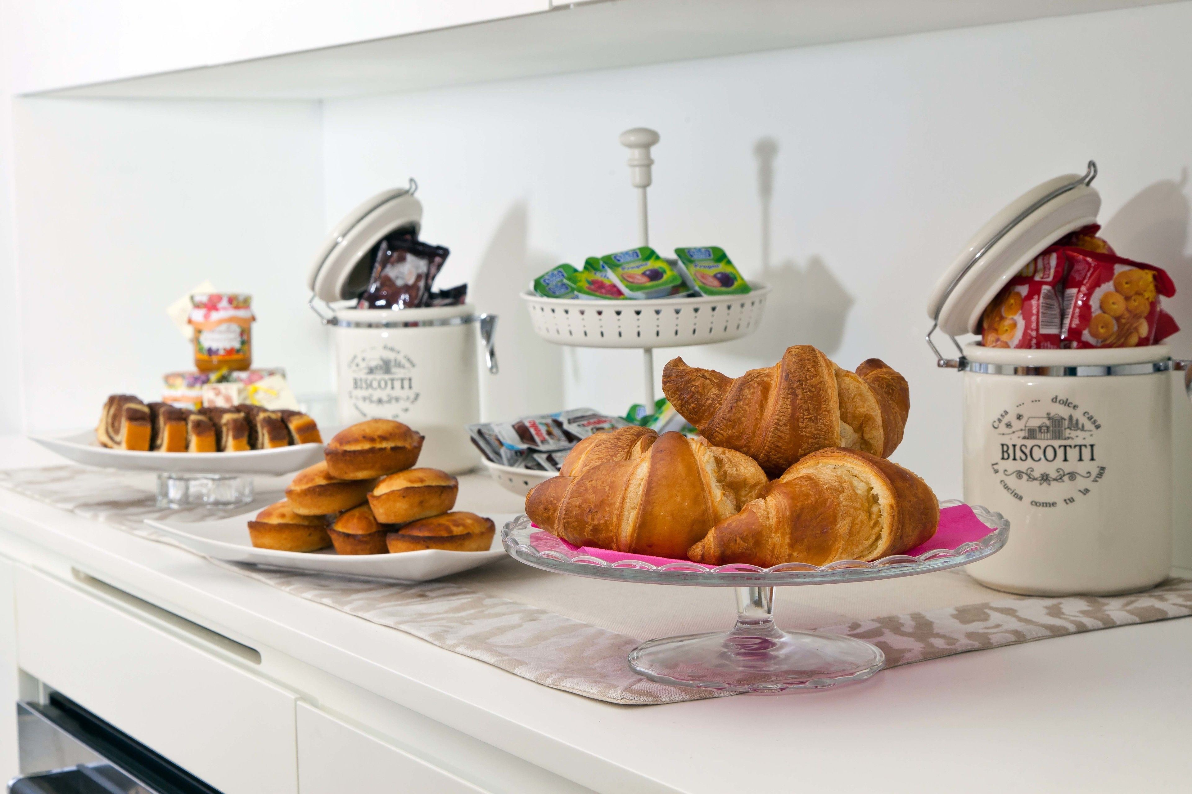 A buffet table with various baked goods and condiments.