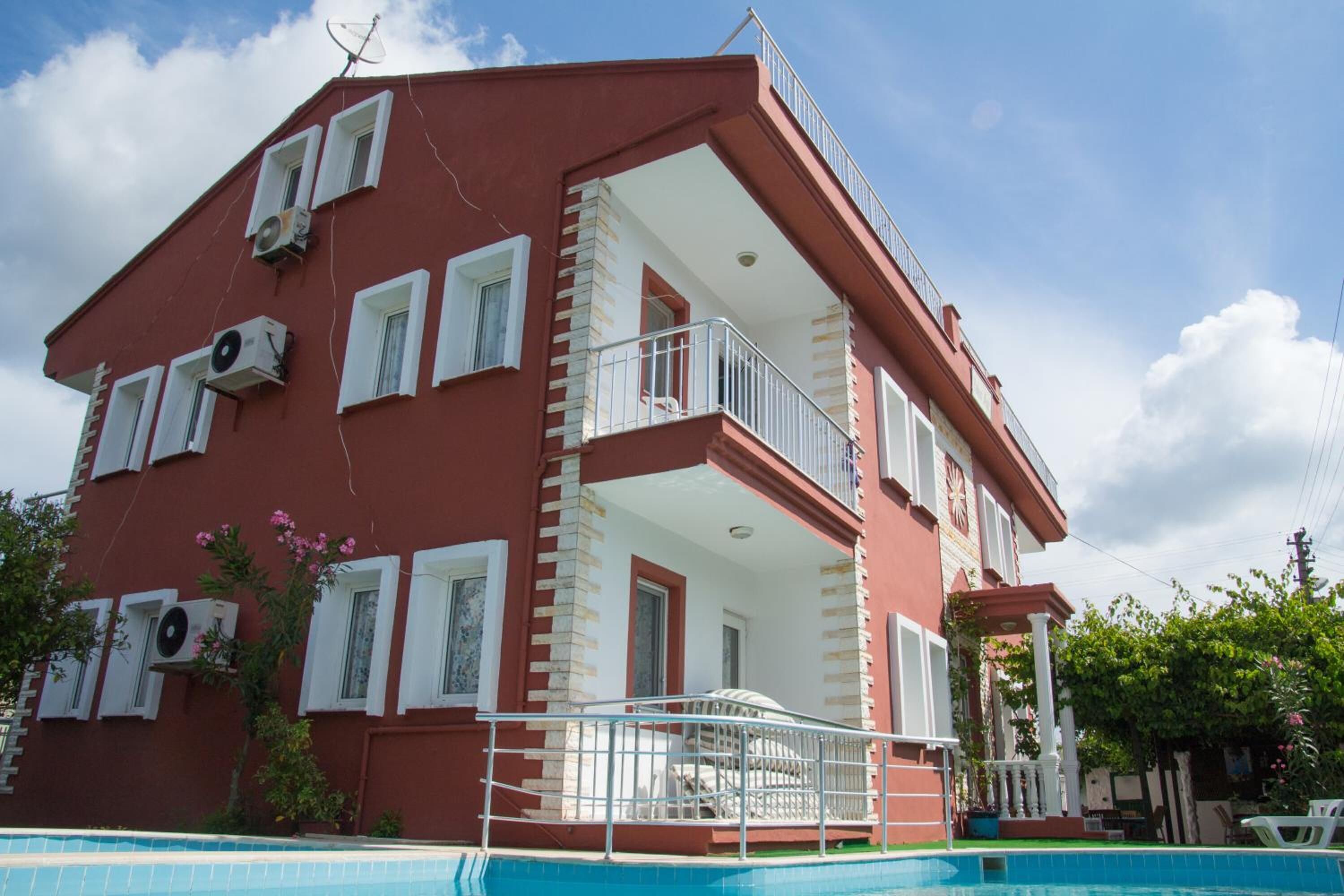 Um edifício com várias andares, varandas, piscina e aparelhos de ar condicionado.