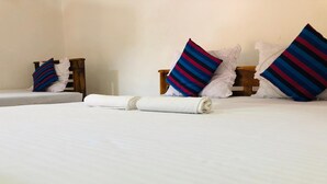 Una habitación de hotel con una cama grande, dos mesitas de noche y almohadas a rayas.