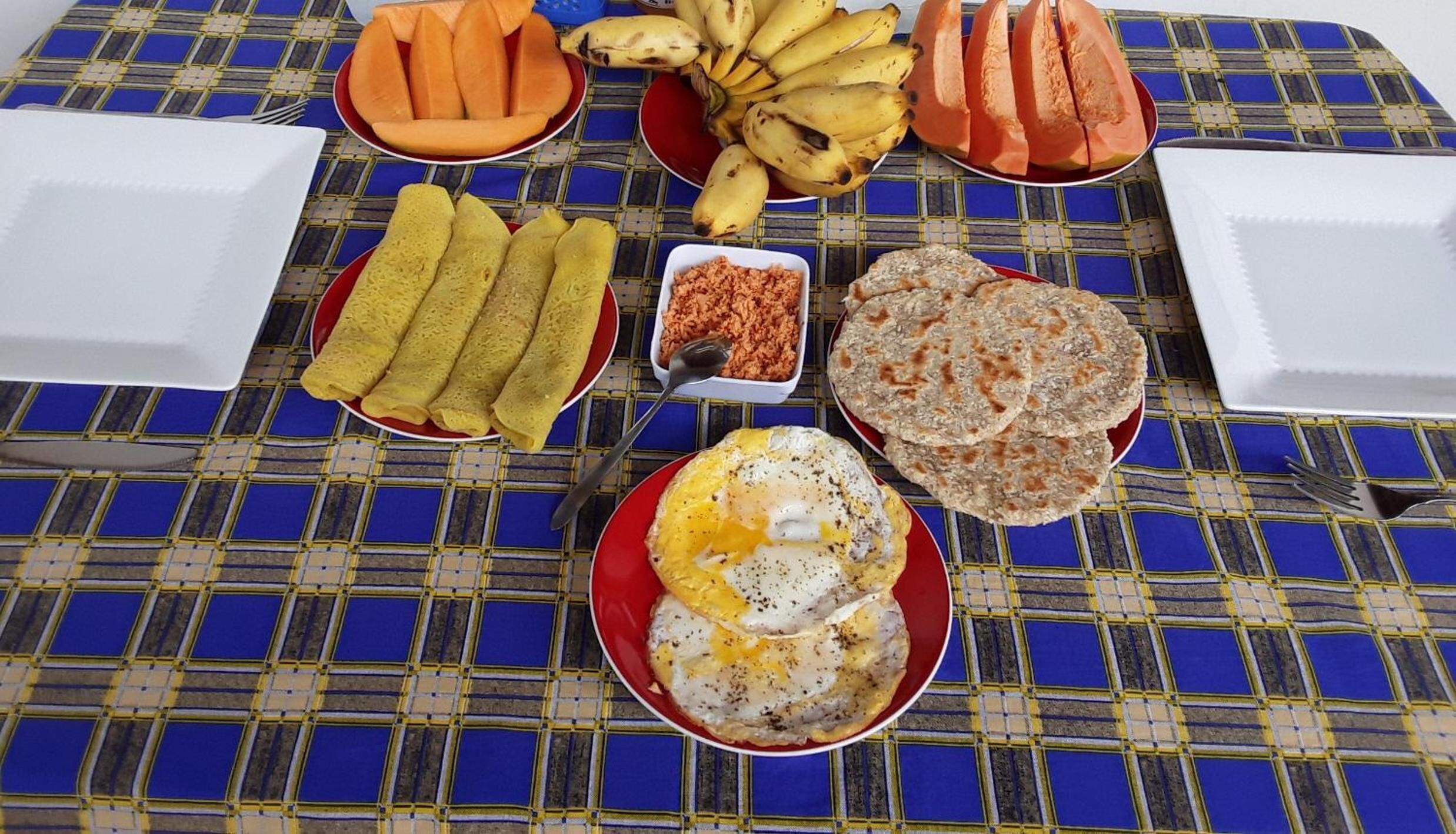 A table with various food items including bananas, bread, and a fried egg.
