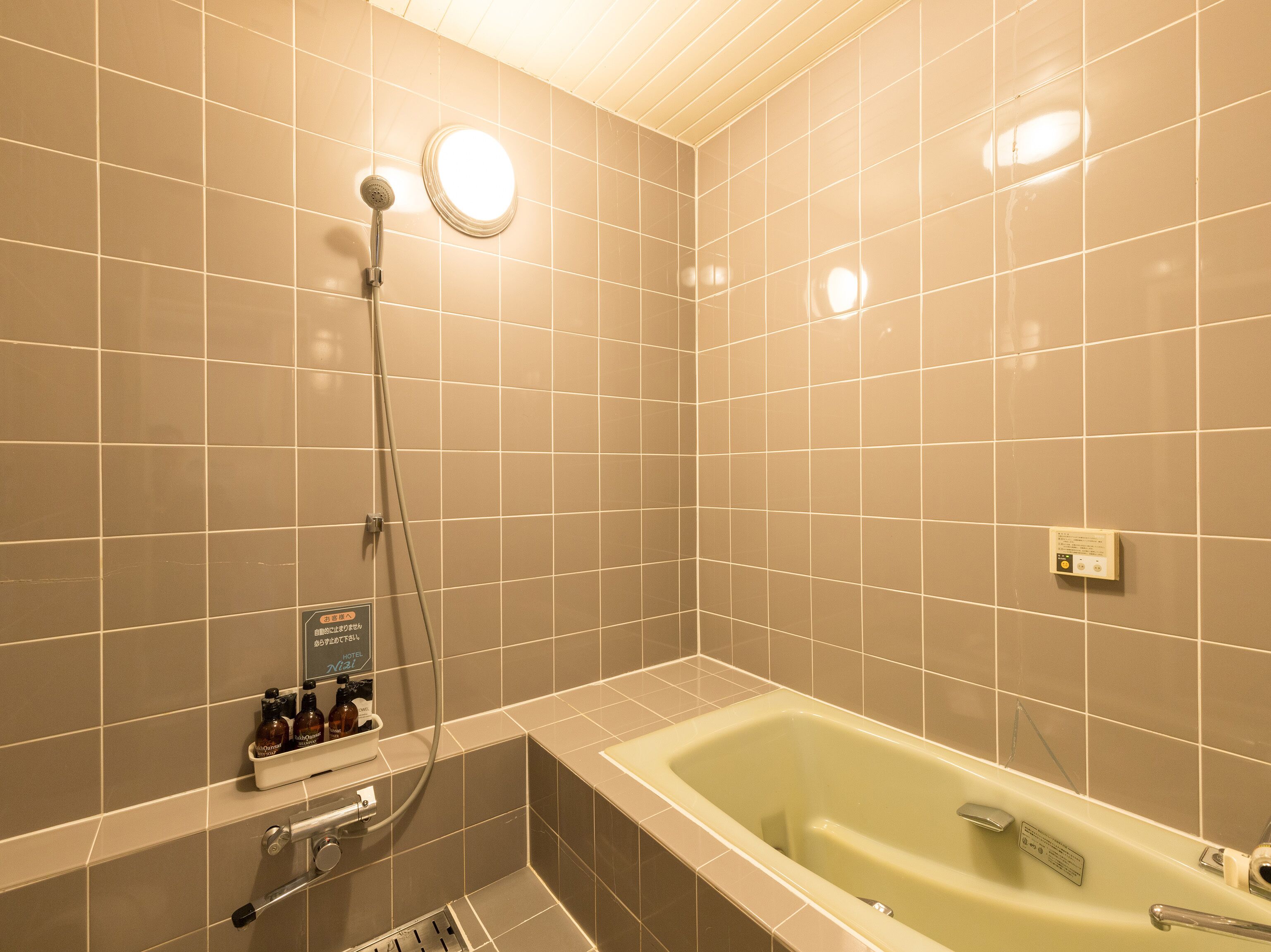 A modern bathroom with a bathtub, a shower, and a hand dryer.