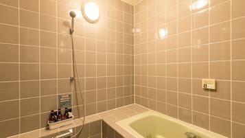 A modern bathroom with a bathtub, a shower, and a hand dryer.