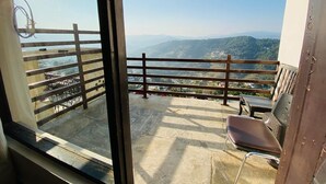 A balcony with a view of distant hills, a wooden railing, and a chair. - Hotel Shivalik - Best Himalaya View Hotel In Almora' (Almora)