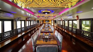 A long dining car with a central table, chairs, and a patterned ceiling. - Hotel Shivalik - Best Himalaya View Hotel In Almora' (Almora)