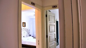 A bedroom with a bed, a bedside table, and a wall-mounted picture frame. - Foca 1887 Otel (Foça)