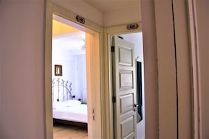 Quarto com cama, mesa de cabeceira e um quadro pendurado na parede.