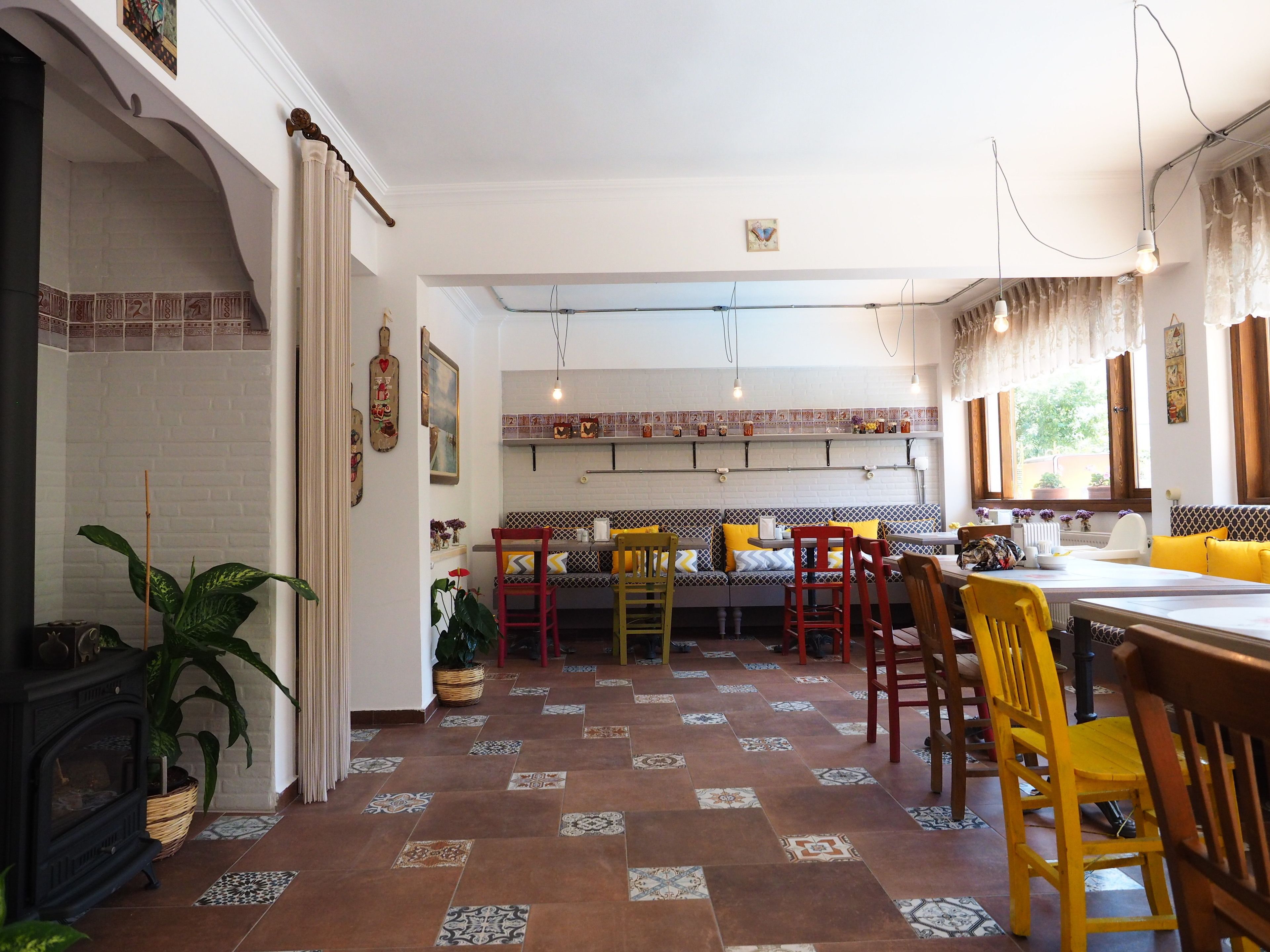 Un comedor acogedor con una mesa larga y sillas, una chimenea y un suelo de baldosas.