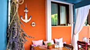 A cozy room with a wooden table, a bench, and a hanging lavender garland. - Foca 1887 Otel (Foça)