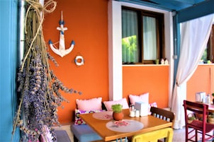 Um quarto aconchegante com uma mesa de madeira, um banco e um guirlanda pendente de lavanda.