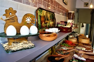 Disposição de buffet com diversos alimentos e utensílios de servir.