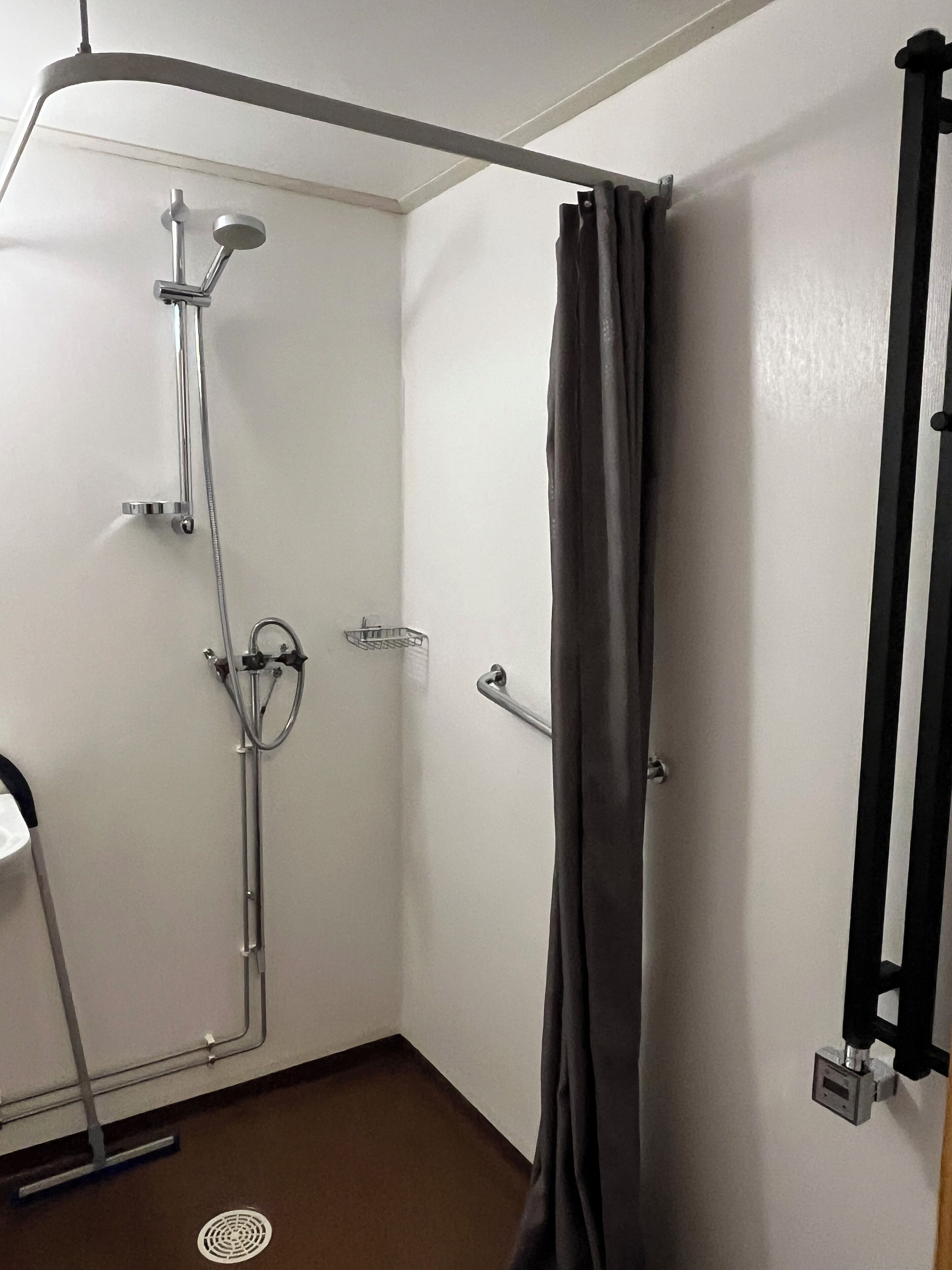 A bathroom with a shower, a toilet, and a sink.