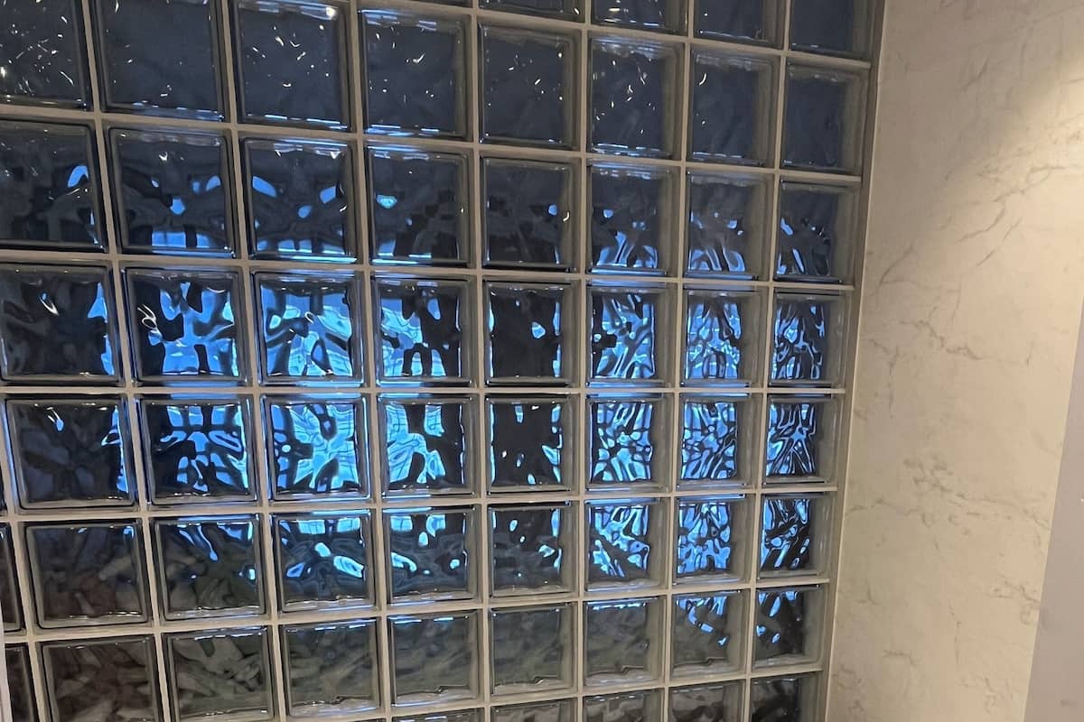 Une baignoire avec un mur carrelé derrière.