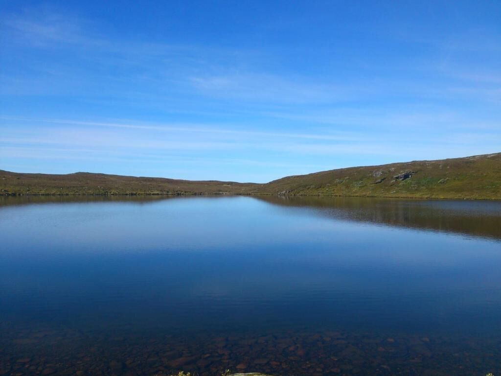 A calm lake surrounded by hills.