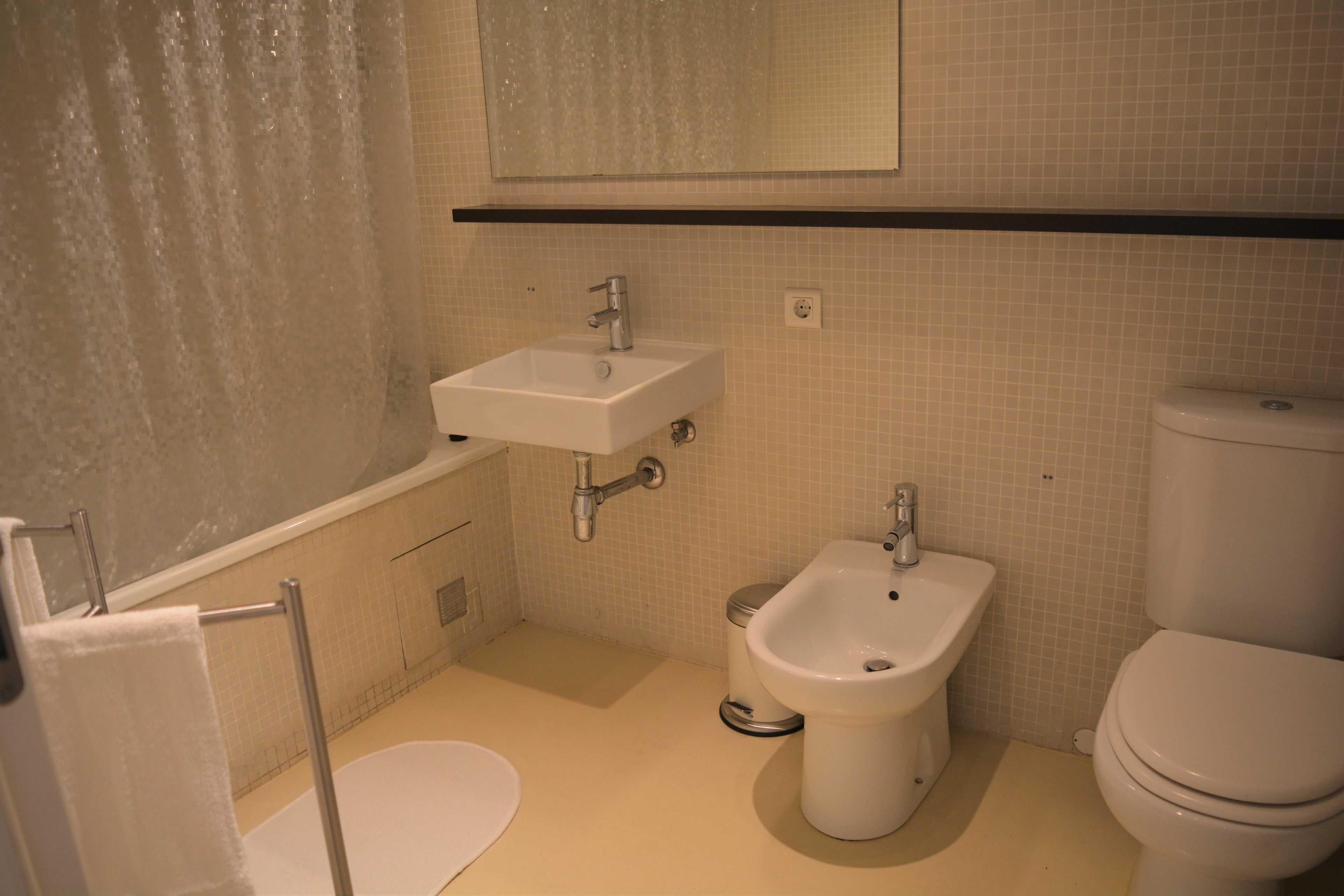 A bathroom with a bathtub, a sink, a bidet, and a toilet.
