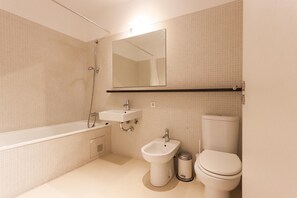 Un baño moderno con bañera, lavamanos, bidé e inodoro.