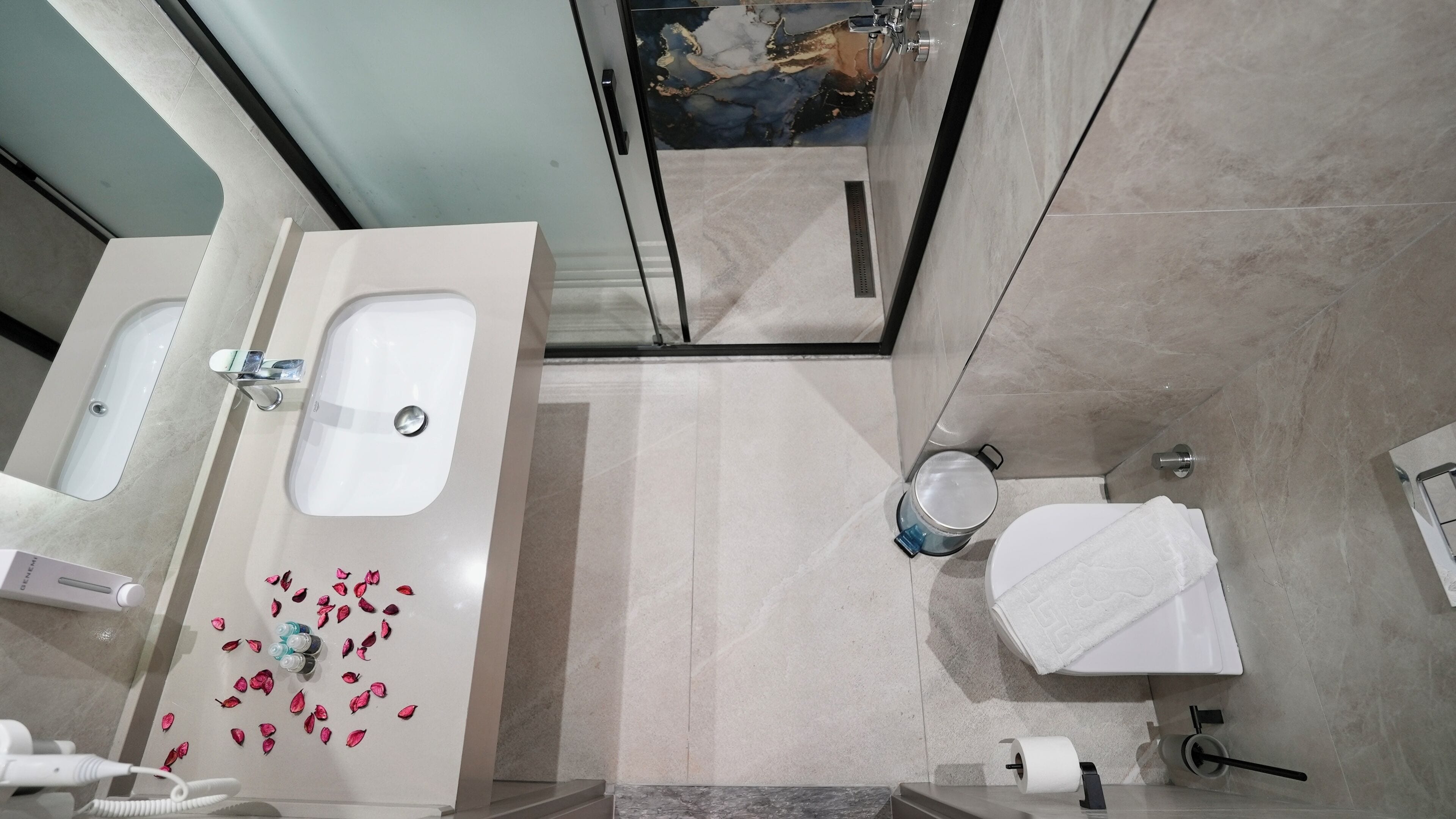 A bathroom with a white sink, a mirror, a towel rack, and a toilet.