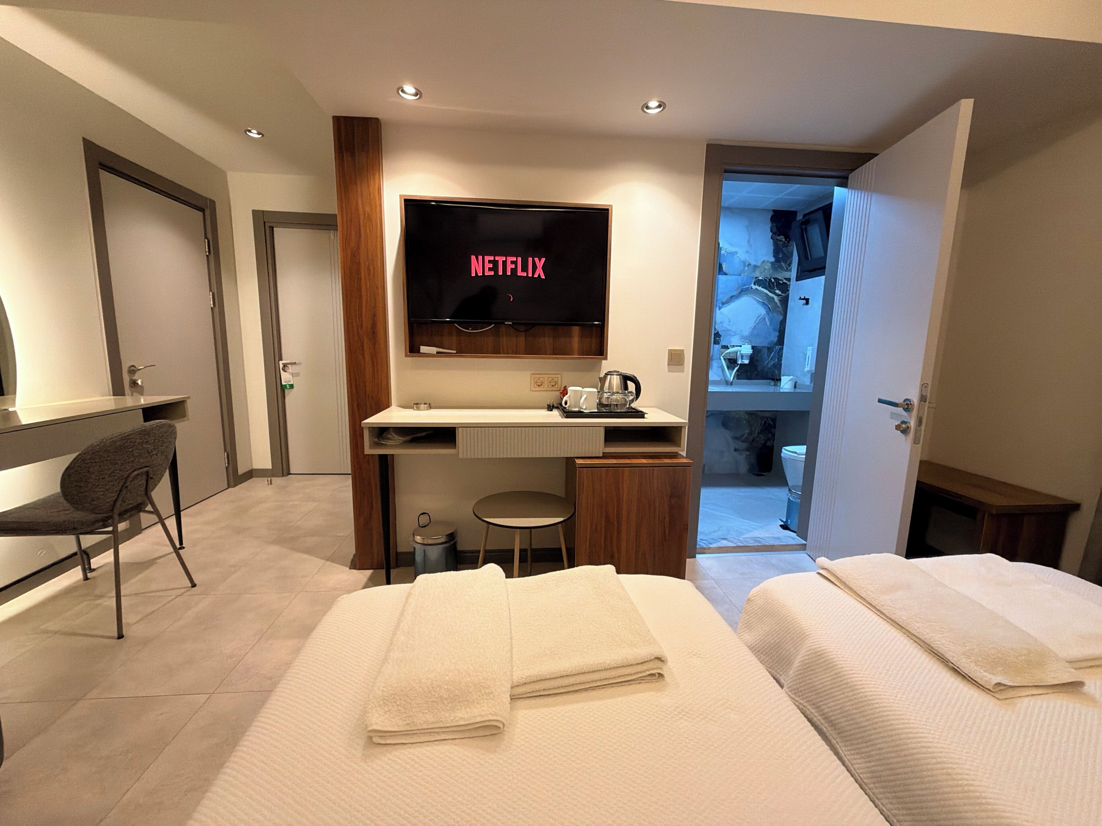 Habitación triple Deluxe | Área de sala de estar | Televisión LCD 