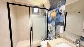 Habitación Deluxe doble | Baño | Ducha, artículos de higiene personal gratuitos y secador de pelo