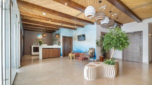 A spacious lobby with a reception desk, seating area, and a large potted plant. - Beach Walk Boutique (Dubai)