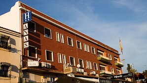 A multi-story brick building with a sign reading "H ANAS" and multiple air conditioning units on the facade. - Hostal Anas (Merida)