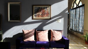 A room with a purple sofa, a chessboard, and a painting on the wall. - Gulaab Niwaas Palace (Pushkar)