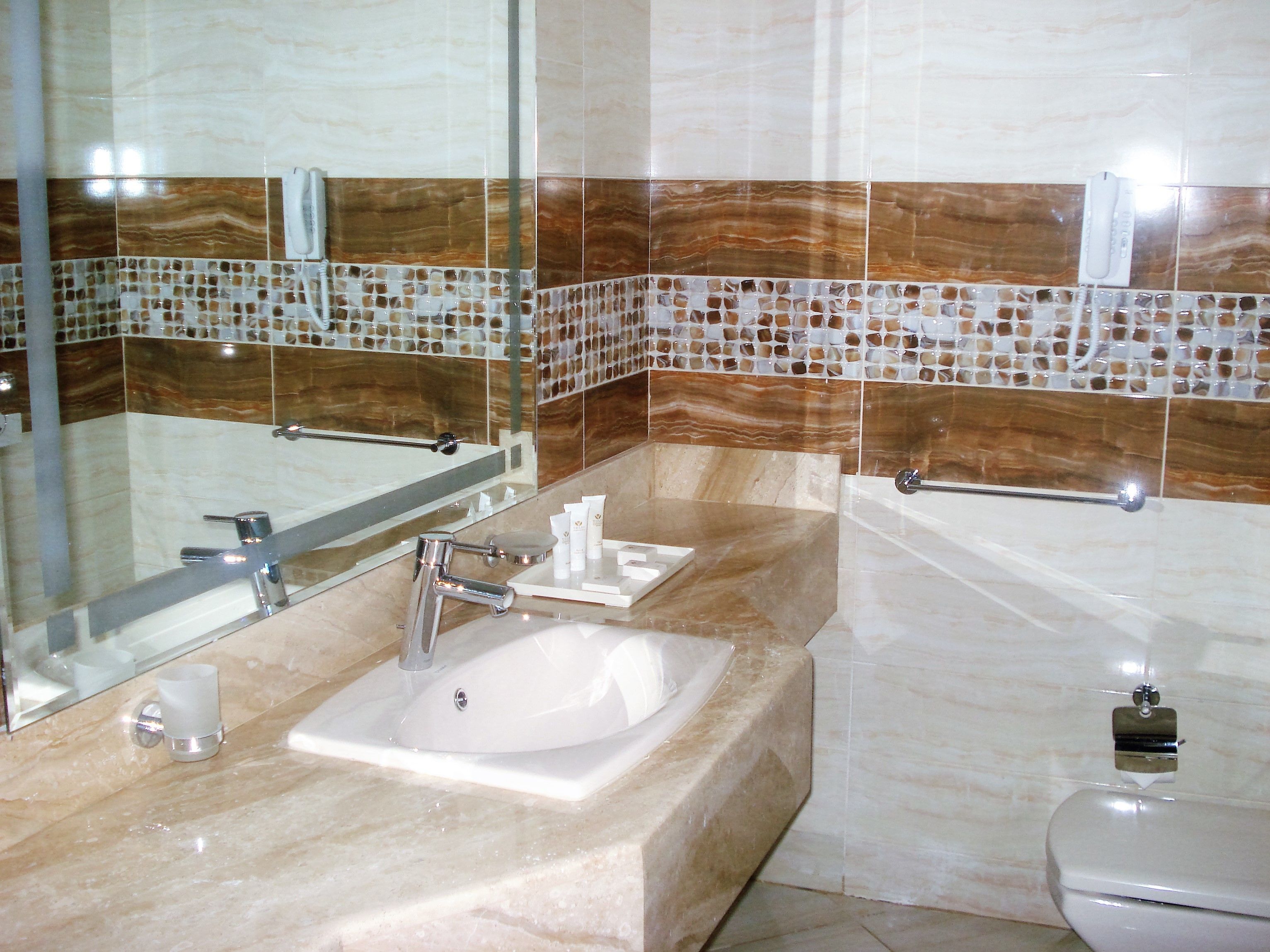 A bathroom with a sink, mirror, and bathtub.