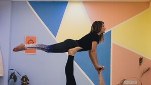 A yoga session in a room with a geometric wall design, a ceiling fan, and a small Buddha statue. - Amigos India - Hostel (New Delhi)