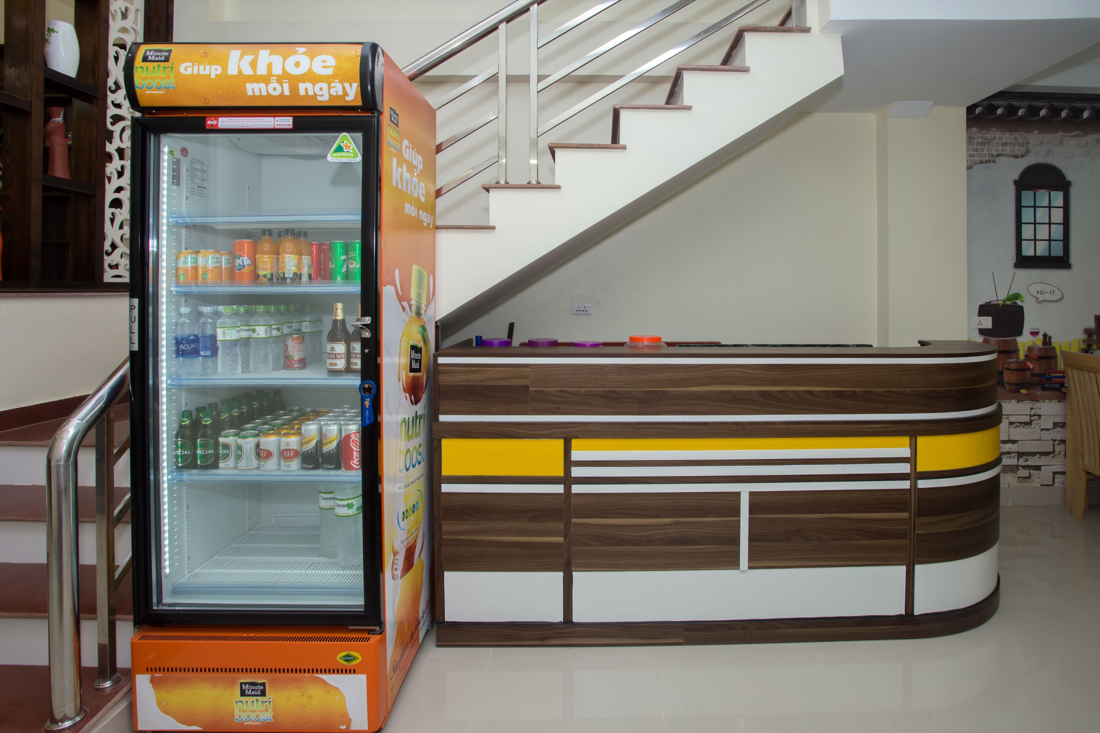A vending machine stocked with beverages and a wooden counter with a modern design.