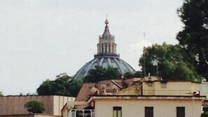 A building with a dome and a spire, surrounded by other buildings. - Ager Vaticanus (Rome)