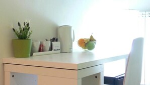 A small kitchenette with a microwave, a coffee maker, a potted plant, and a bowl of fruit. - Ager Vaticanus (Rome)