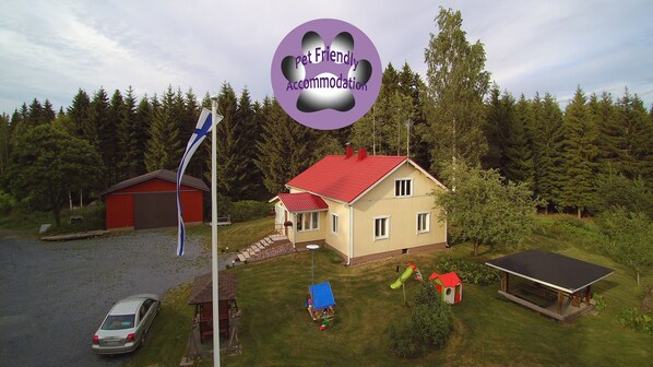Situated in a forested area, this house features a front porch and a small garden, perfect for relaxation.