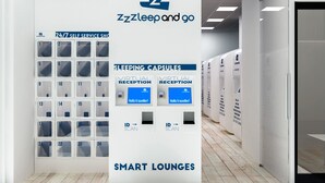 Un moderno vestíbulo de hotel con una tienda autoservicio abierta las 24 horas, cápsulas para dormir, recepción virtual, escaneo de identificación y salones inteligentes.