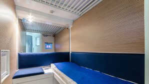 Una habitación de hotel moderna con una banca incorporada, un escritorio pequeño y una ventana.