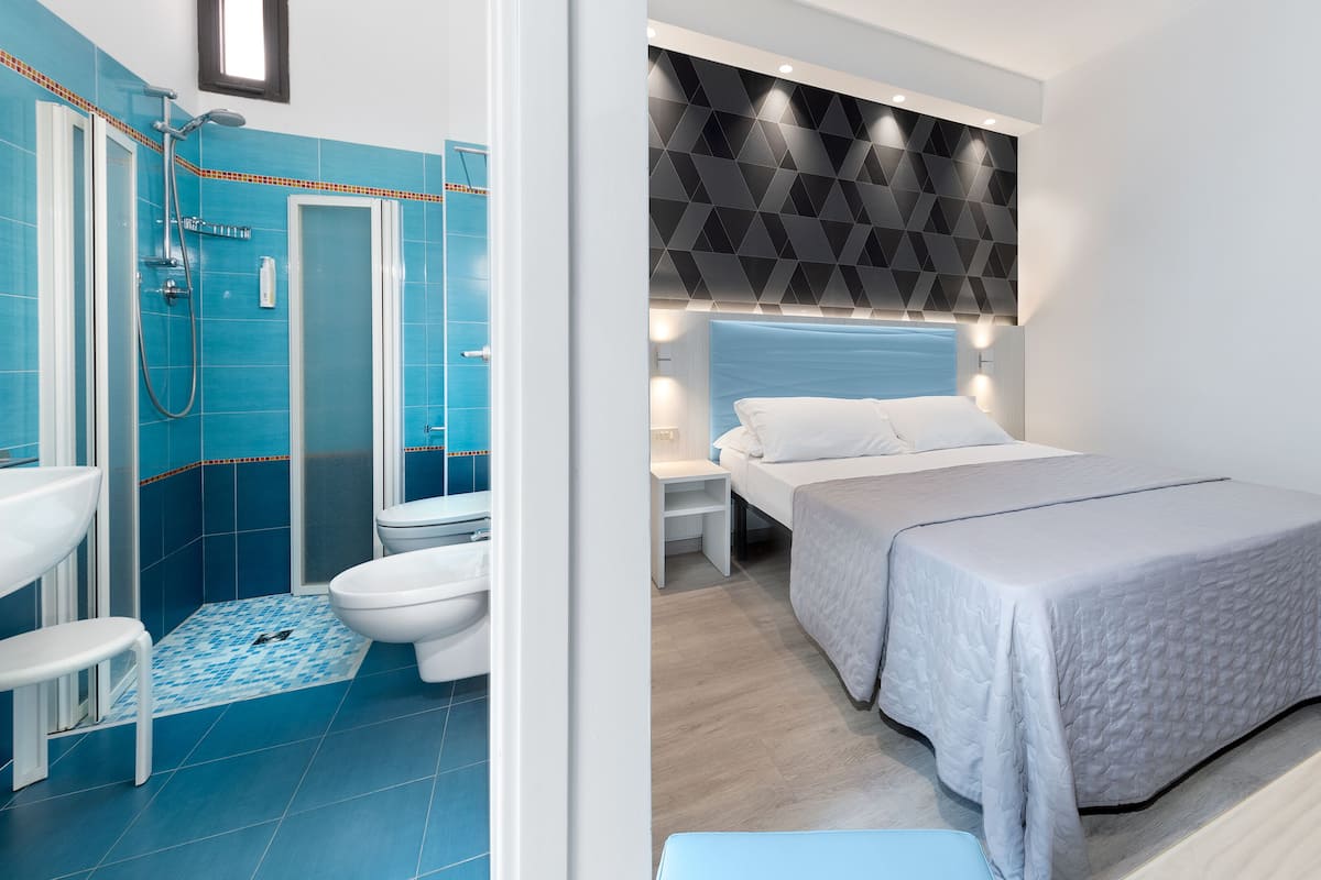 A modern bathroom with a shower, toilet, and sink.