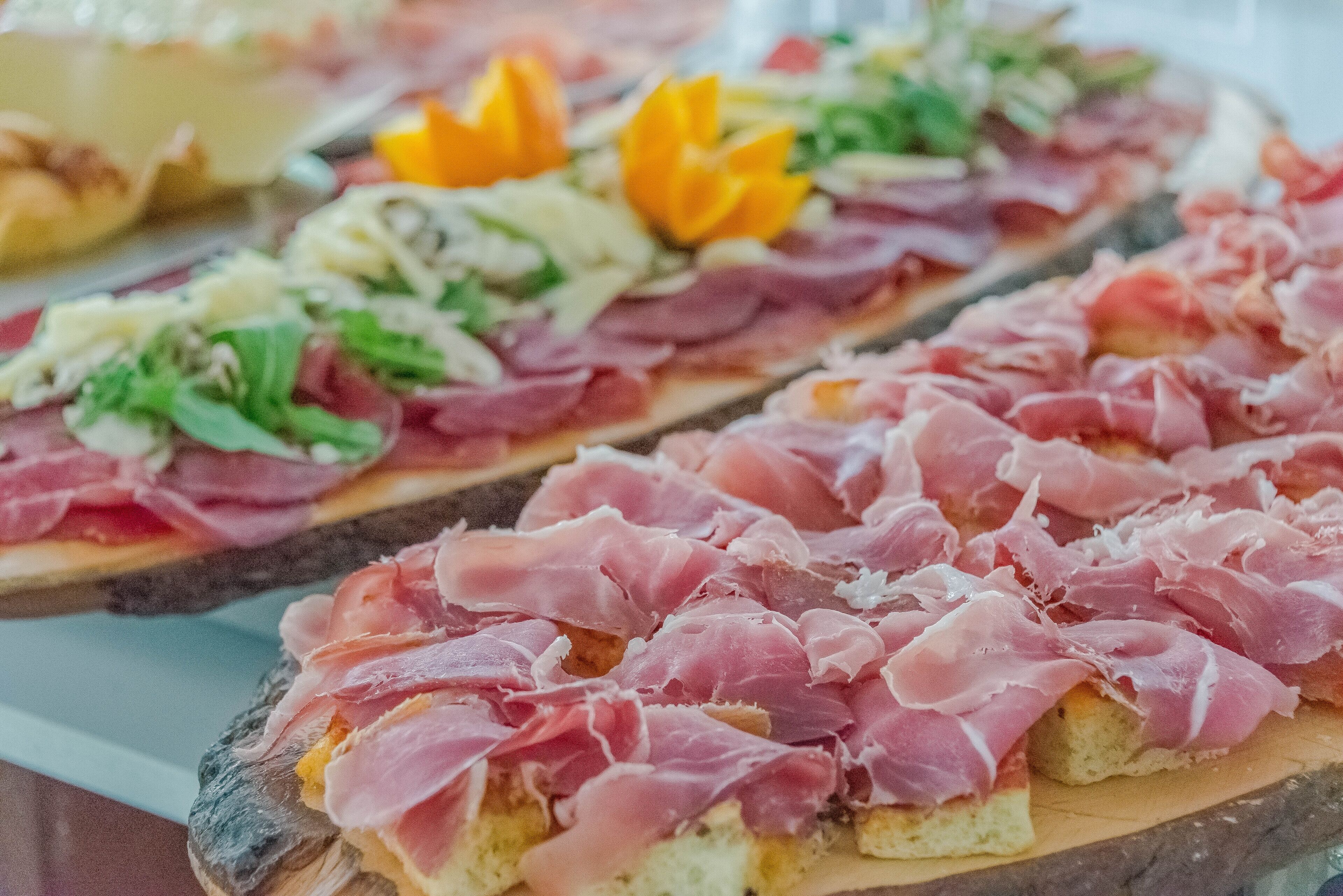 Verschiedene Vorspeisen, darunter Bruschetta belegt mit Prosciutto und weiteren Zutaten.