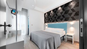Une chambre à coucher moderne avec un lit, une table de chevet et une tête de lit à motifs géométriques.