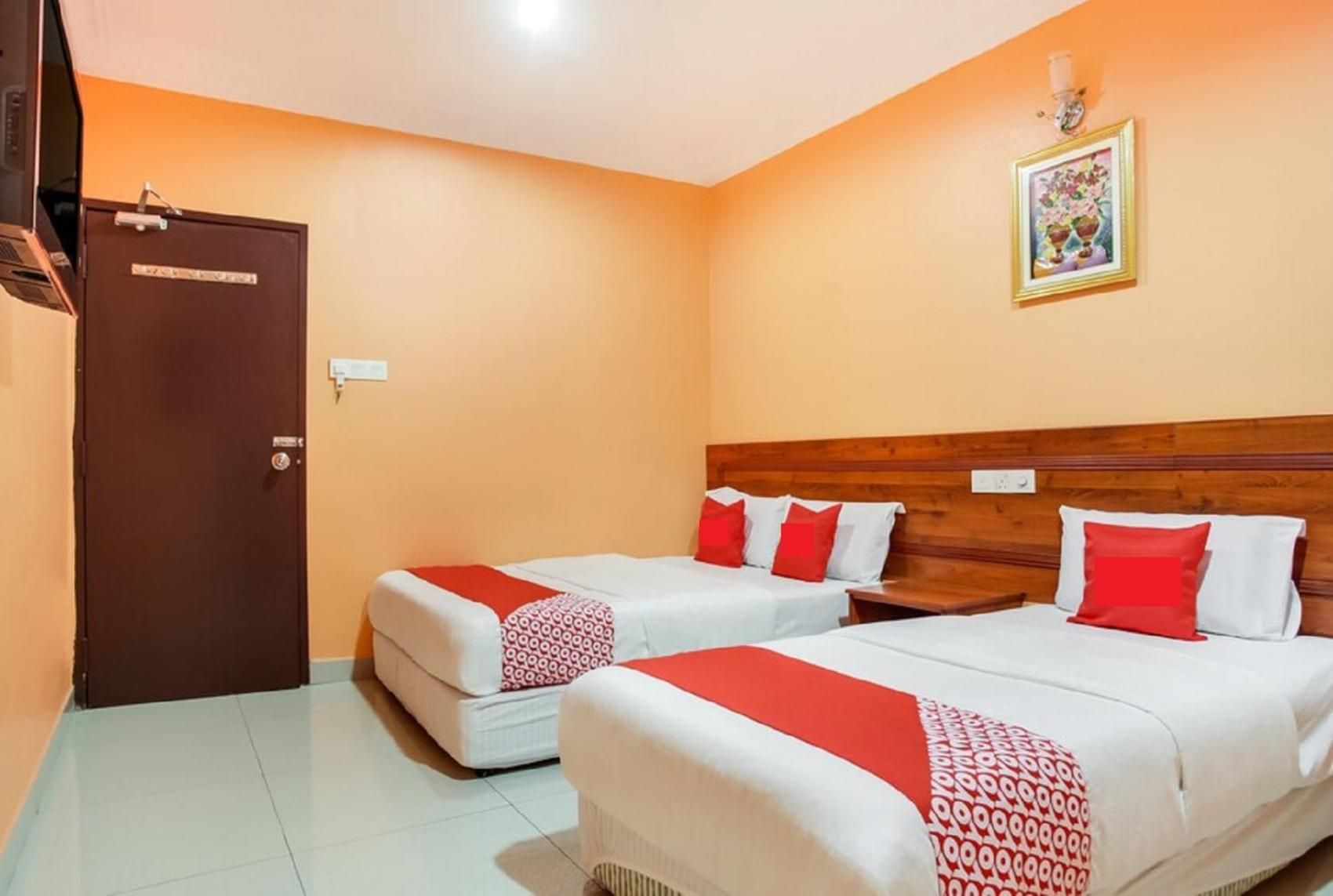 A hotel room with two beds, a wardrobe, and a wall-mounted picture.