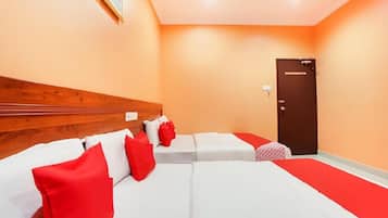 Une chambre d’hôtel avec une tête de lit en bois, deux lits avec une literie rouge et blanche, une moquette rouge et une porte.