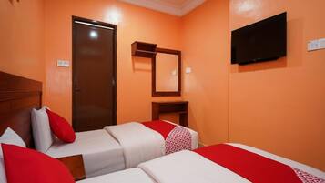 A hotel room with two beds, a television, a door, and a mirror.
