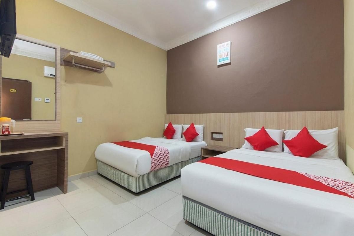 Habitación de hotel con dos camas, un escritorio y un espejo.