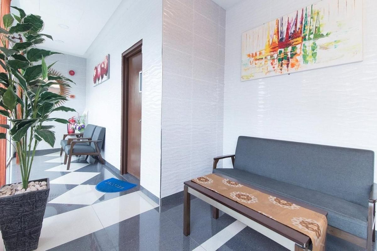 Un hall d’hôtel comprenant un comptoir d’accueil, un espace salon et une grande peinture abstraite accrochée au mur.
