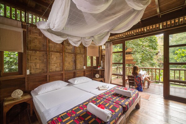 Una habitación con una cama grande, cabecera de madera y vistas al exterior.