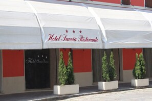A restaurant named Hotel Savoie Restaurante with a white awning and three potted plants in front. - Hotel Savoia (Poggio Rusco)