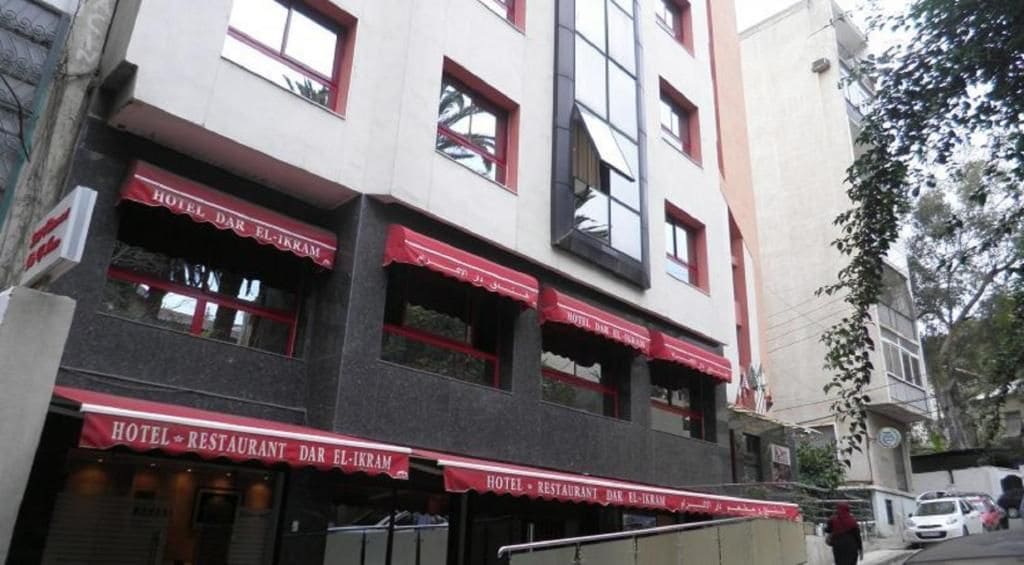 Un edificio de varios pisos con un restaurante en la planta baja y habitaciones en los pisos superiores.