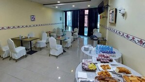 A dining area with tables set for breakfast, including pastries and beverages. - Hotel Ikram (Algiers)