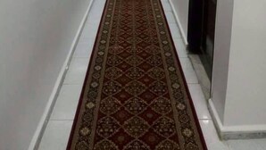 A hallway with a patterned carpet, white walls, and a door on the right. - Hotel Ikram (Algiers)
