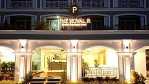 L’entrée d’un hôtel, avec une enseigne indiquant : « THE ROYAL ».