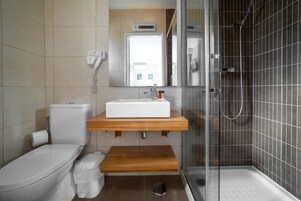Un baño moderno con inodoro, lavamanos y ducha.