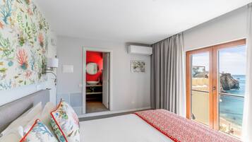 Ein Hotelzimmer mit Bett, Bad, Meerblick und Balkon.