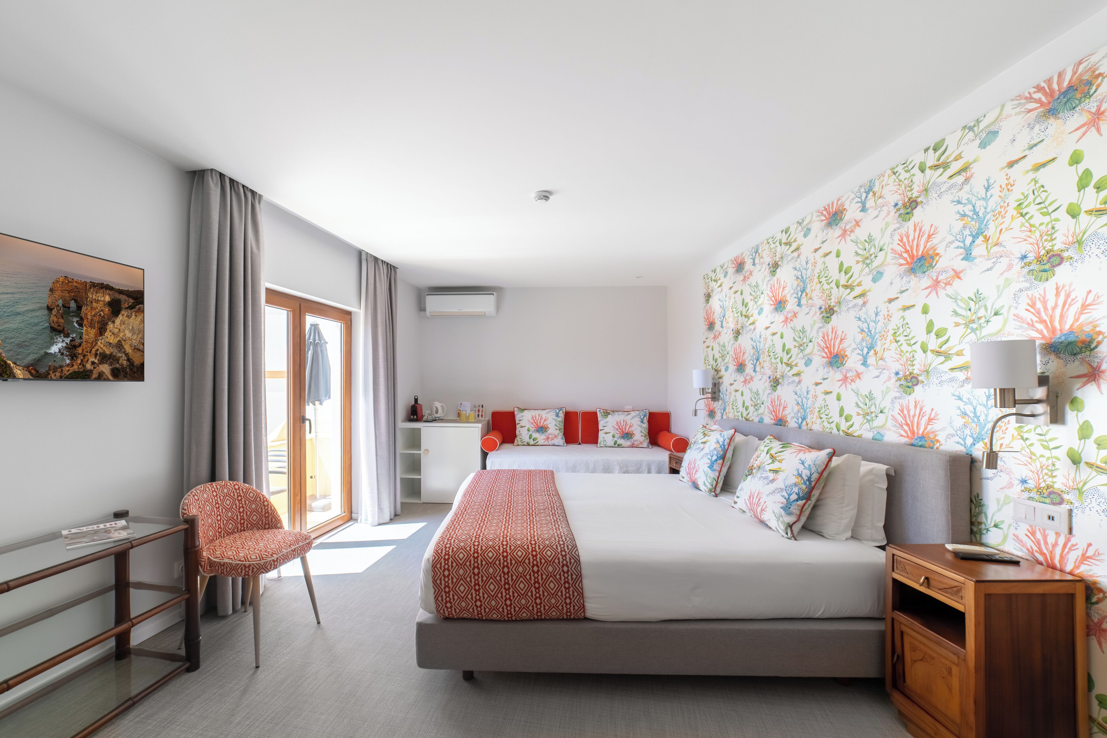 A modern hotel room with a large bed, a desk, and a chair.